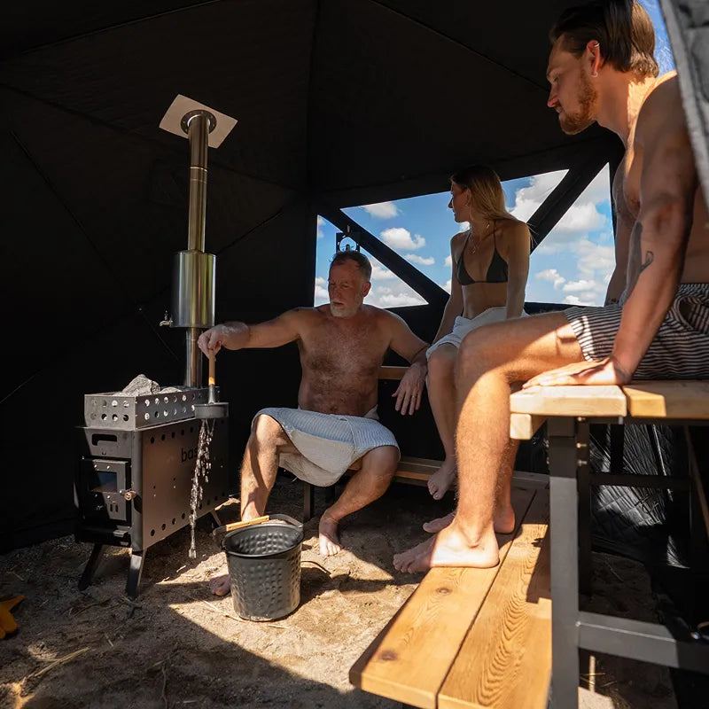 Bast Björk Deluxe Zeltsauna mit Ofen, mehrere Personen nutzen die tragbare Sauna im Freien