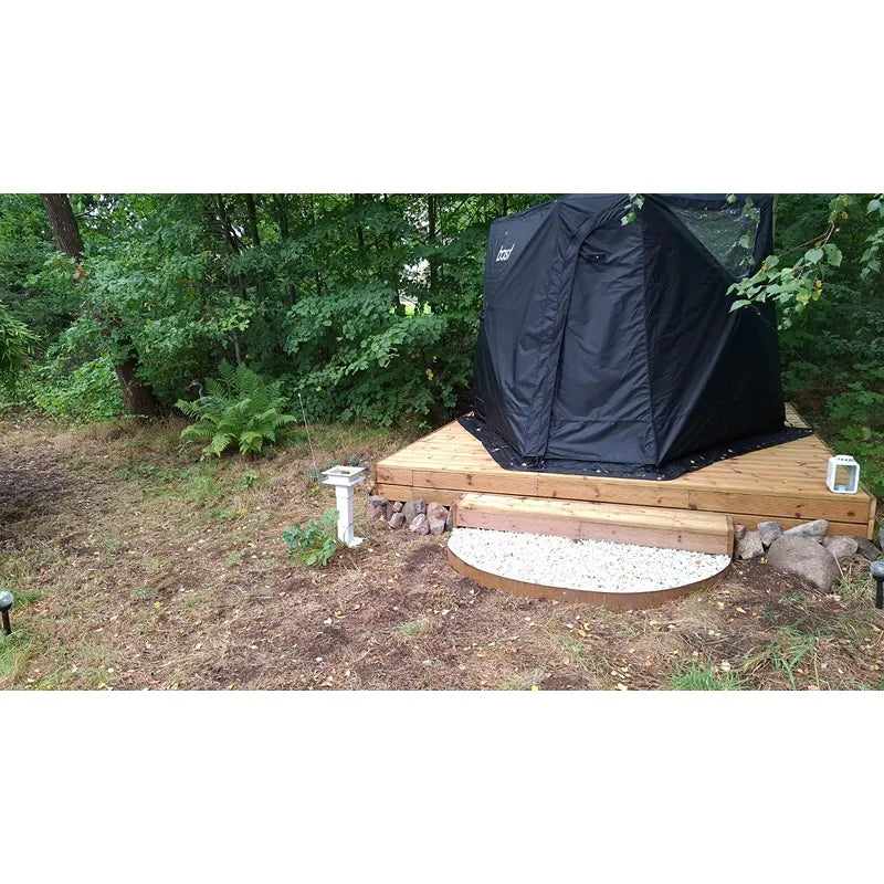 Bast Björk Deluxe Zeltsauna schwarz auf Holzplattform im Garten, tragbare 4-10 Personen Sauna über 100°C