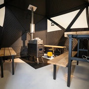 Innenansicht der Bast Björk Deluxe Zeltsauna mit mehreren Holzbänken und Ofen