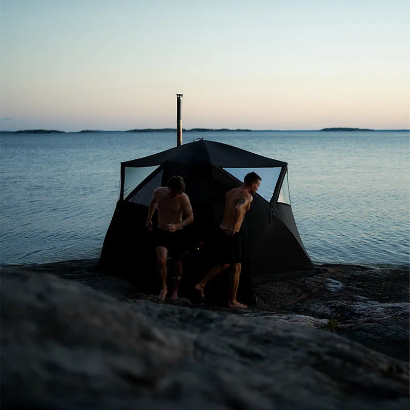 Bast Björk Premium Zeltsauna am Strand mit zwei Personen, tragbare Gartensauna für 4-10 Personen bei Sonnenuntergang