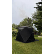 Bast Björk Premium Zeltsauna in schwarzer Farbe aufgebaut im Garten mit Rauch aus dem Kamin, tragbare Gartensauna für 4-10 Personen