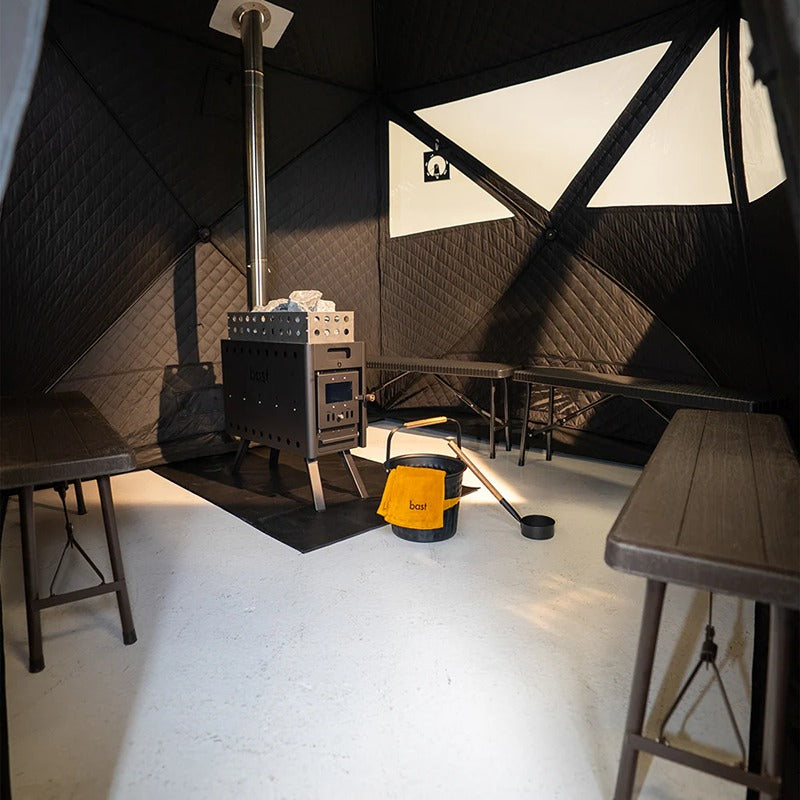 Innenraum der Bast Björk Premium Zeltsauna mit Saunaofen, Bänken und Bodenfläche