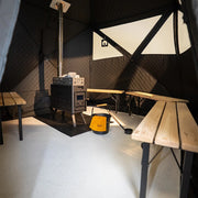 Innenraum der Bast Björk Premium Zeltsauna mit Saunaofen, Bänken und Fenstern