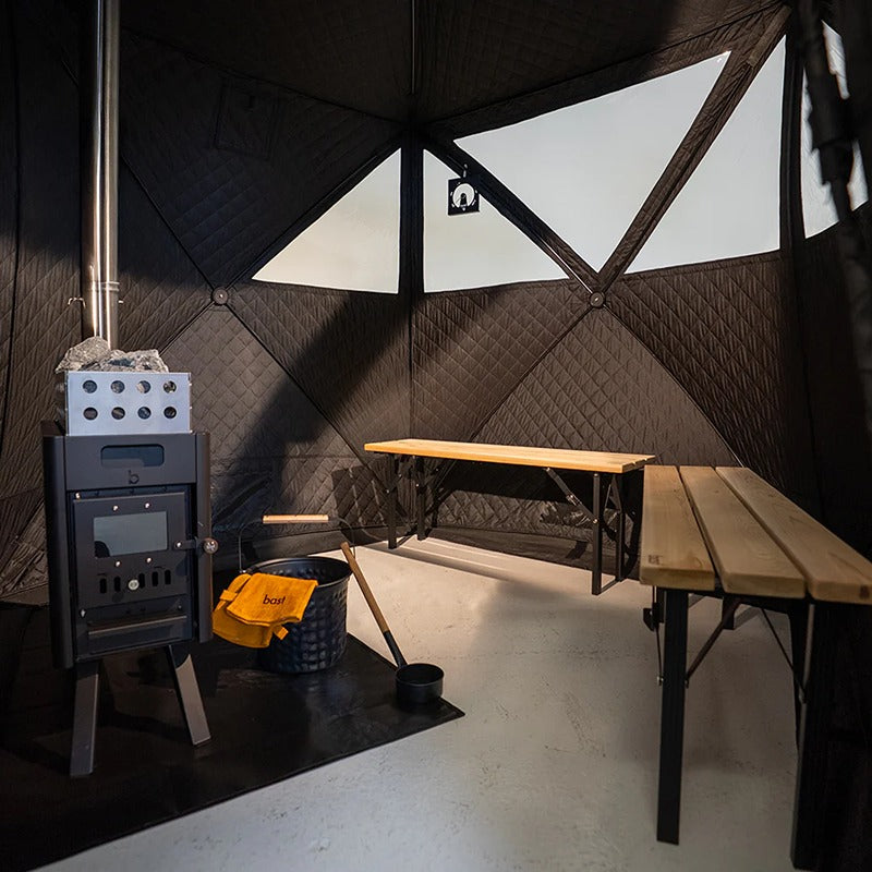 Innenraum der Bast Näver Premium Zeltsauna mit Edelstahlofen, Saunasteinen und einstufiger Sitzbank