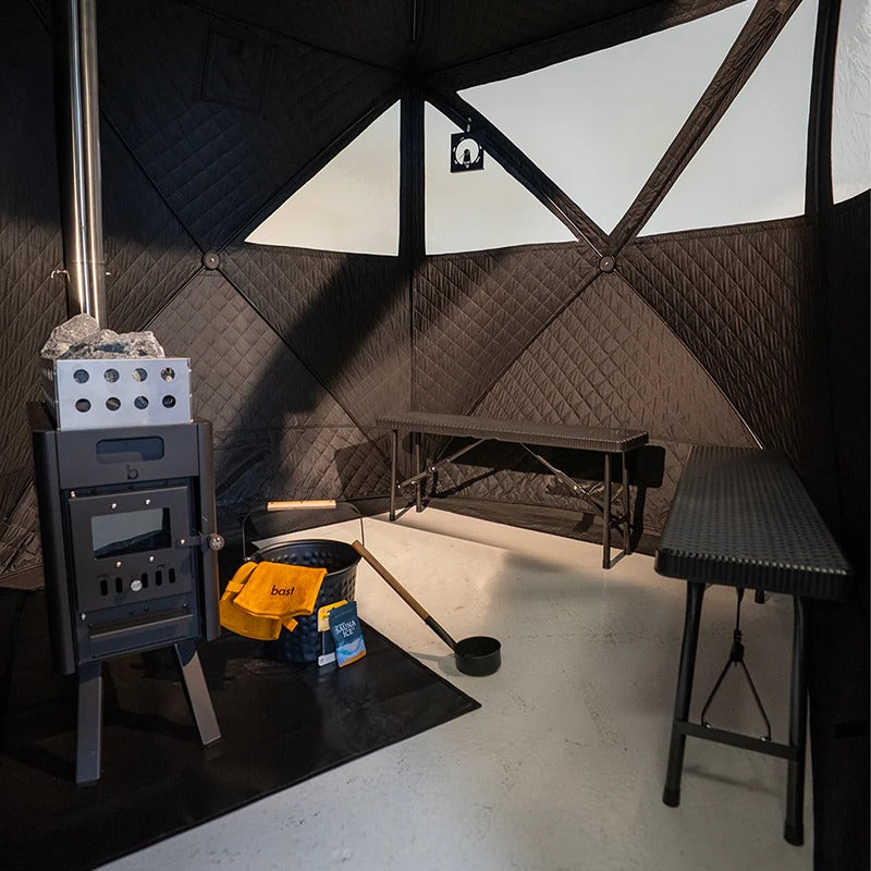 Innenansicht der Bast Näver Premium Zeltsauna mit klappbarer Kunststoffbank und integriertem Ofen