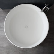 Weiße freistehende Mineralguss Badewanne EAGO AWT StoneArt BS-507 von oben, rundes Design mit verchromter Armatur seitlich angebracht, moderne Badezimmereinrichtung auf Betonboden.
