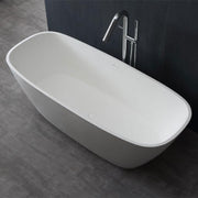 Freistehende weiße Mineralguss Badewanne EAGO AWT StoneArt BS-528 mit ovaler Form und Chromarmatur auf dunklem Badezimmerboden vor schwarzer Wand.
