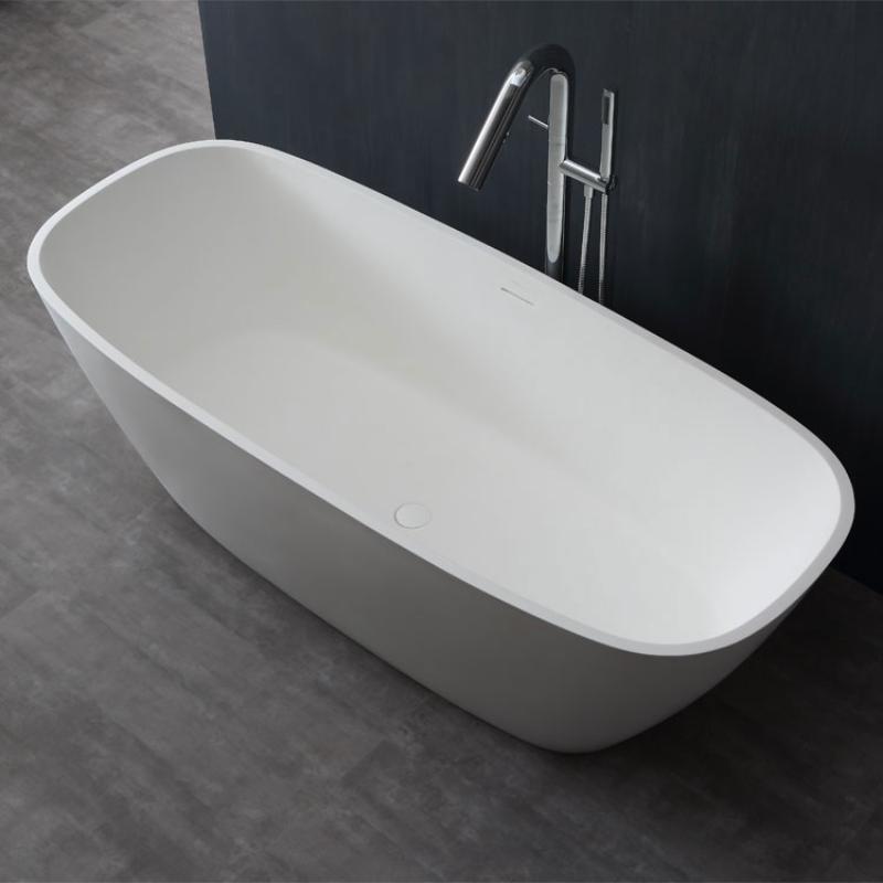 Freistehende weiße Mineralguss Badewanne EAGO AWT StoneArt BS-528 mit ovaler Form und Chromarmatur auf dunklem Badezimmerboden vor schwarzer Wand.