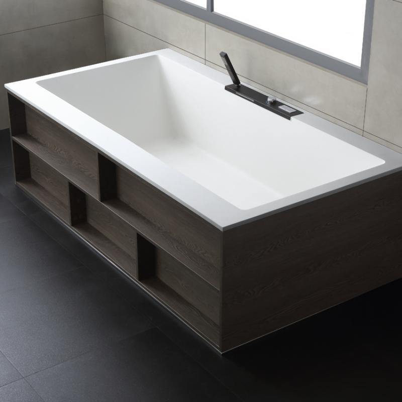 Freistehende Mineralguss Badewanne EAGO AWT StoneArt BS-536 in Weiß mit dunklem Holzsockel und schwarzer Armatur in modernem Badezimmer.