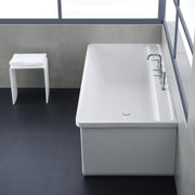 Freistehende weiße Mineralguss Badewanne EAGO AWT StoneArt BS-537 mit Armatur im minimalistischen Badezimmer neben weißem Hocker