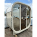 Celsium Ula Mini Sauna in Beige mit Ganzglasfront während der Montage – kompakte Designsauna für zwei Personen mit heller Holzoptik und sanft gerundeter Form