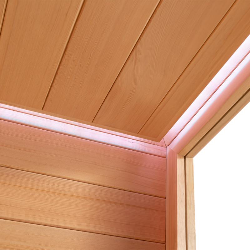 Detailaufnahme der Holzdecke und oberen Saunawand mit Fichte-Verkleidung und LED-Beleuchtung in rosa-weißem Licht