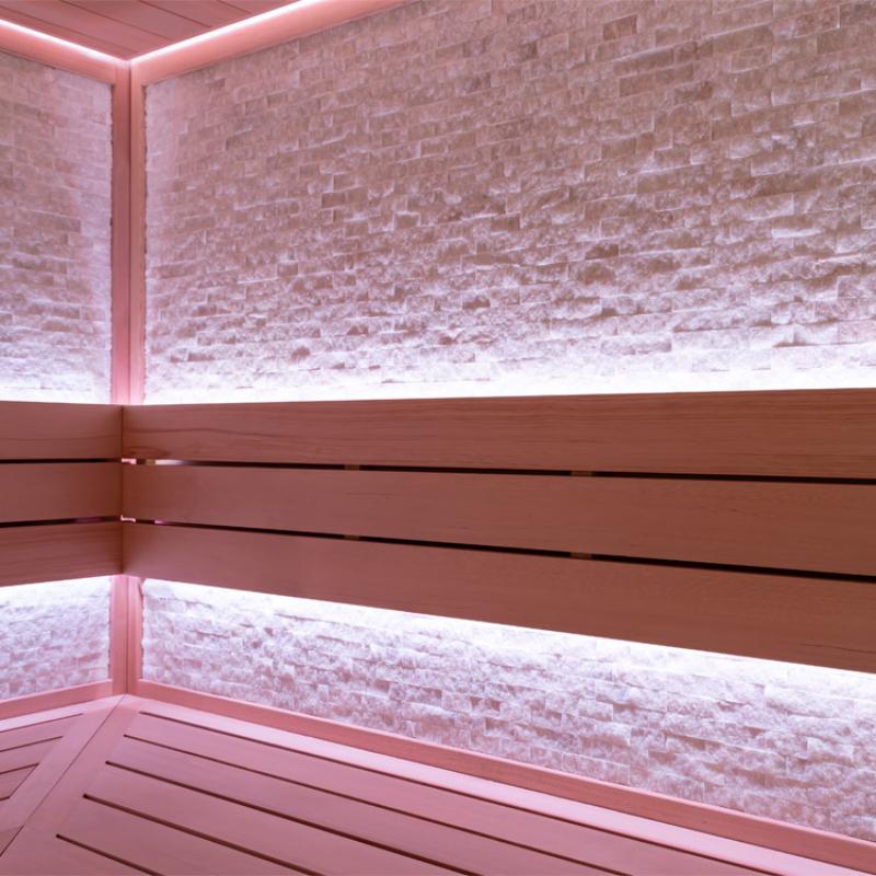 EAGO AWT E1603C Infrarot-Sauna Innenansicht mit Holzbänken, rosa LED-Beleuchtung und Ziegelmauer-Design