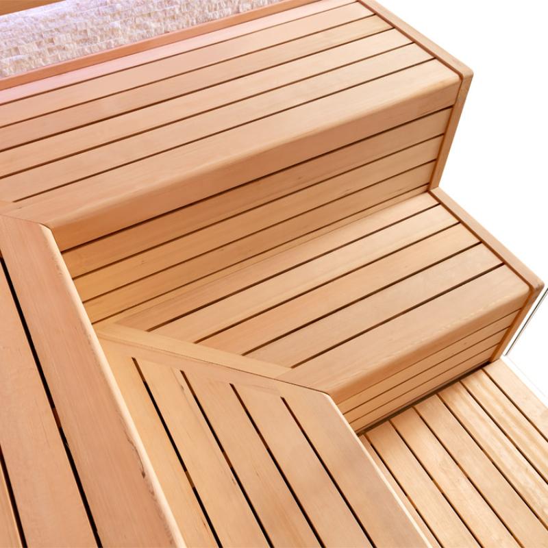 Detailaufnahme der Holzbänke in der EAGO AWT E1603C Sauna aus Hemlock-Holz mit geschwungenen Sitzflächen und Rückenlehnen