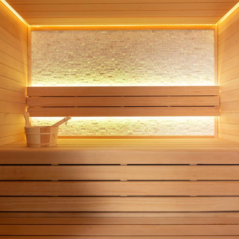 Innenraum der EAGO AWT E1604A Hemlock Sauna mit Holzaufbau, LED-Beleuchtung, zwei Saunabänken und Holzeimer auf der unteren Bank