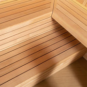Blick in das Innere einer Hemlock-Sauna mit Holzbänken in mehreren Ebenen und hellem Nadelholz-Design