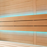 Holzsauna mit heller Hemlock-Verkleidung, integrierten LED-Leuchten in Türkis und modernen schwarzen Akzentleisten, moderne Designelemente