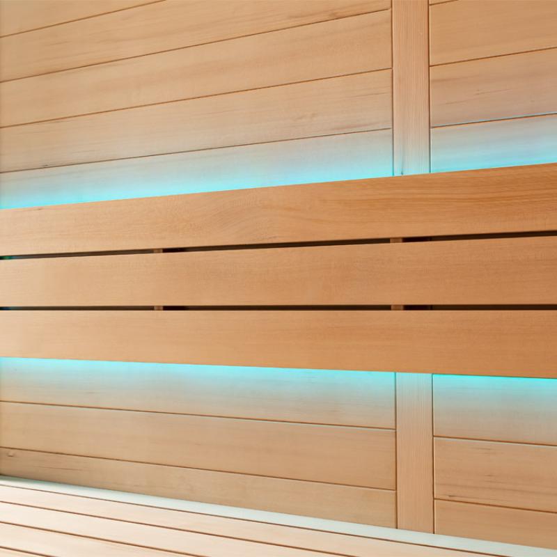 Holzverkleidung einer modernen Sauna mit integrierten LED-Leuchten in Blau, Hemlock-Holz und horizontalen Bänken mit schwarzen Akzenten