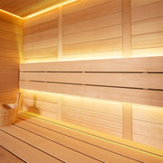 Modernes Saunainnenraum aus Hemlock-Holz mit LED-Beleuchtung, zwei durchgehenden Sitzbänken und Holzeimer in warmer Atmosphäre