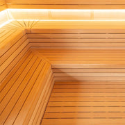 Holzverkleidung einer Sauna mit horizontalen Fichtenbrettern und abgerundeter Ecke, warmhell erleuchtet