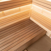 Innenansicht einer modernen Holzsauna EAGO AWT E1621B mit heller Hemlock-Holzverkleidung, Sitzbänken und warmweißer LED-Beleuchtung an den Wänden
