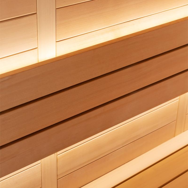 Detailaufnahme der Holzverkleidung einer Hemlock-Sauna mit horizontalen Holzbrettern in natürlichen Brauntönen und heller LED-Beleuchtung an den Kanten