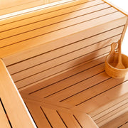 Innenansicht der EAGO AWT E1623C Hemlock Sauna mit hellen Holzbänken, Rückenlehne und Holzkelle in der Ecke