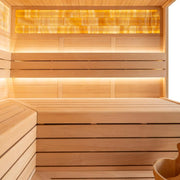Innenraum einer Hemlock-Sauna mit Holzbänken, LED-Beleuchtung und Infrarotheizung an der Wand