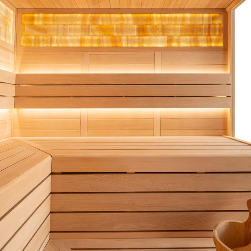 Innenraum einer Hemlock-Sauna mit Holzbänken, LED-Beleuchtung und Infrarotheizung an der Wand