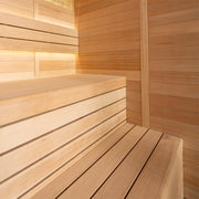 Modernes Saunainnenraum aus heller Hemlock-Holz mit Sitzbank und Rückenlehne, warm beleuchtet
