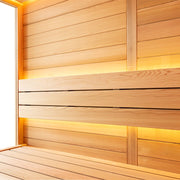 Holzverkleidung einer Saunakabine mit warmem Licht, Bänke aus Zedernholz und durchgehende horizontale Holzbretter in einer modernen Saunenecke