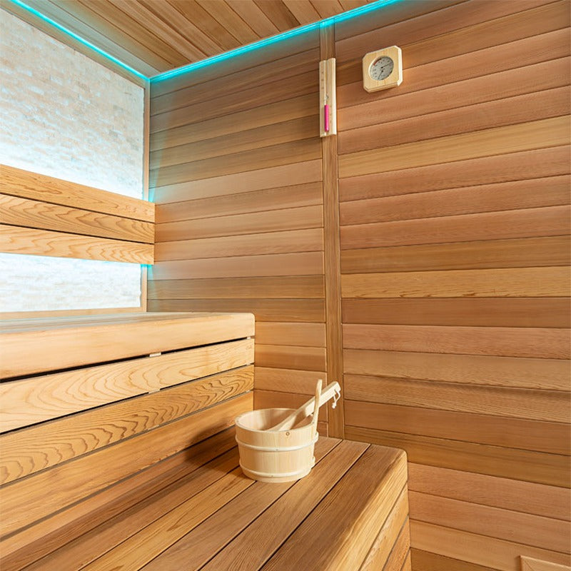 Innenansicht der EAGO E1602B Sauna mit Holzbank, Saunaeimer und Kelle, Thermometer sowie indirekter blauer LED-Beleuchtung entlang der Decke