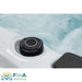 Detailaufnahme eines Bedienknopfes am FinA Xaluna Outdoor Whirlpool, eingelassen in die Acrylwanne mit Wasser im Hintergrund