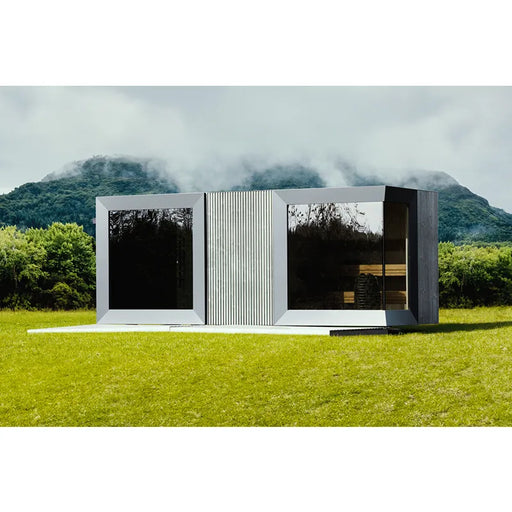 Genevas St. Moritz Modular Sauna Shower mit weißer Fassade und großen Glasflächen in Gartenlandschaft