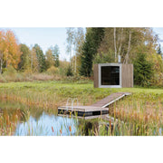 Genevas Zermatt Modular Sauna Compact mit Holzverkleidung im Garten zwischen Bäumen