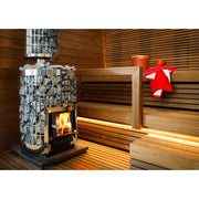 Harvia Cilindro 20 Steel Holzofen Set mit brennendem Feuer in moderner Sauna, Holzbänke und Saunazubehör