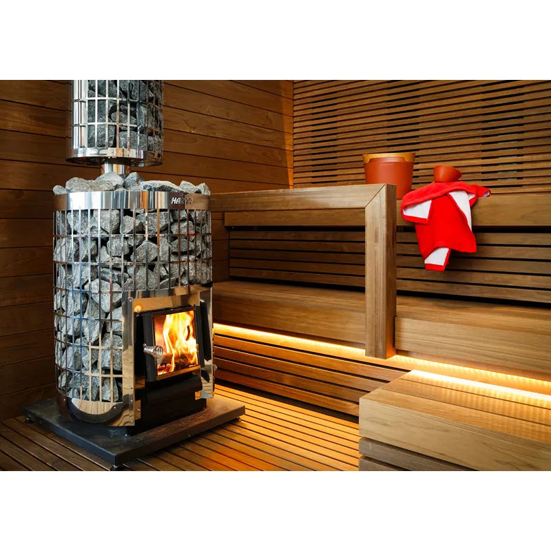 Harvia Cilindro 20 Steel Holzofen Set mit brennendem Feuer in moderner Sauna, Holzbänke und Saunazubehör