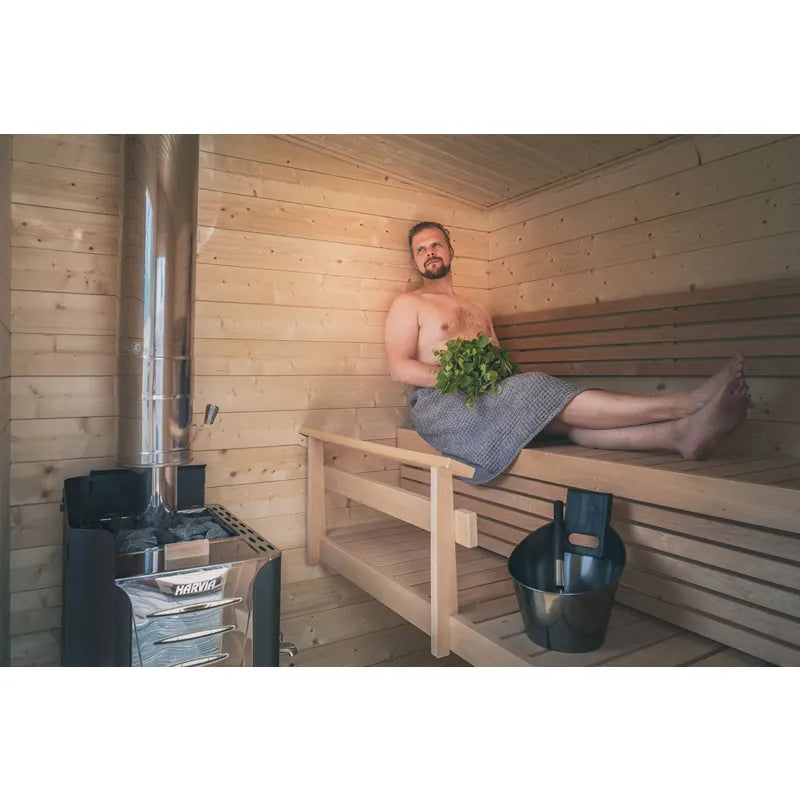 Harvia Schornstein 1500 Edelstahl WHP1500 Saunaofenzubehör in moderner Holzsauna mit Mann auf Holzbank