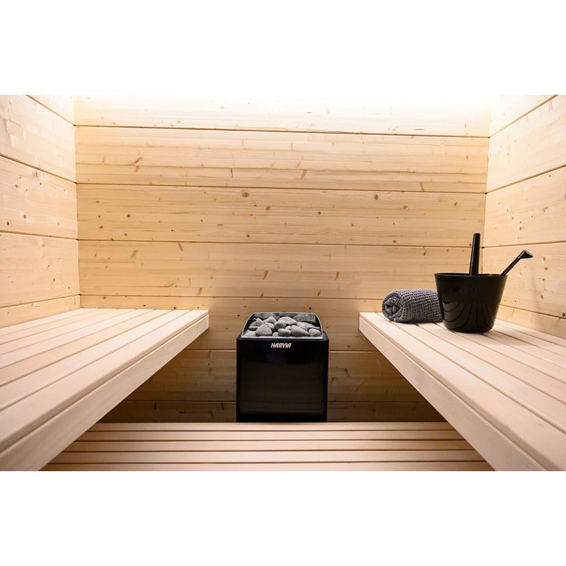 Zentral platzierter Harvia KIP Saunaofen in heller Holzsauna mit zwei gegenüberliegenden Bänken