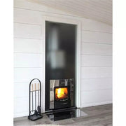 Harvia Legend 300 Holzofen mit brennendem Feuer in moderner Sauna-Nische, schwarze Fassade mit Sichtfenster, Schaufel und Besteck im Vordergrund