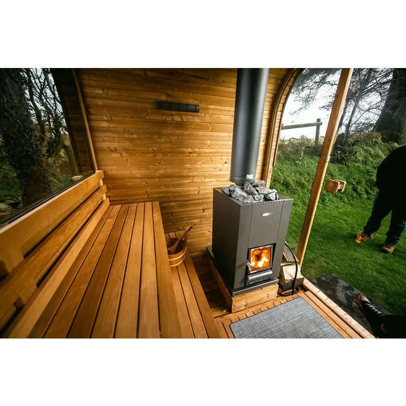 Hekla Cube Gartensauna mit Holzbank, Ofen und großen Fenstern im grünen Garten