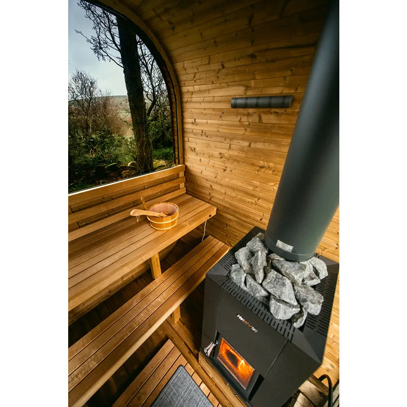 Hekla Cube 160/210/250 Gartensauna Innenansicht mit Holzbänken, Saunaofen und großem Fenster