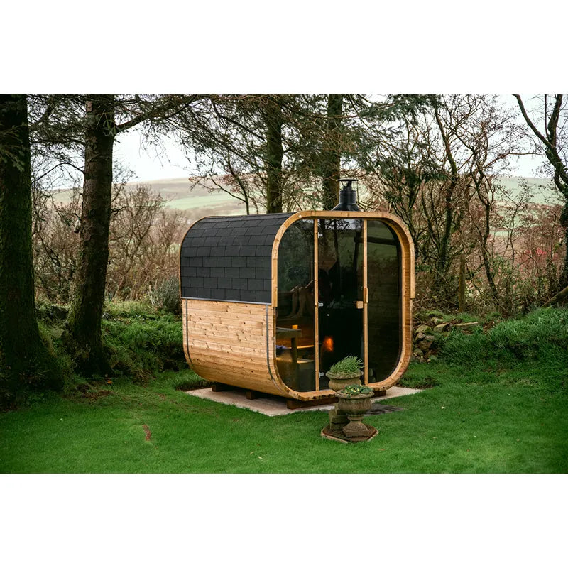 Hekla Cube 160/210/250 Gartensauna mit Holzverkleidung und schwarzem Dach im Garten