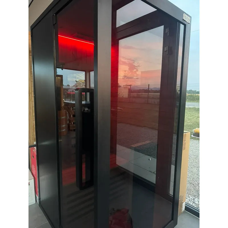 Hekla Infrared 100 Infrarotsauna 1 Person mit rotem Infrarotlicht im Garten bei Sonnenuntergang