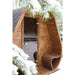 Detailansicht der Herkus Large Outdoor-Gartensauna in dunkelbrauner Holzoptik mit schwarzem Schindeldach und integriertem Vorraum, im verschneiten Wald aufgenommen.