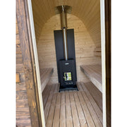 Innenansicht der Herkus Large Gartensauna mit hellem Holzinterieur, zwei Sitzbänken und zentral platziertem schwarzen Holzofen mit Kaminrohr.