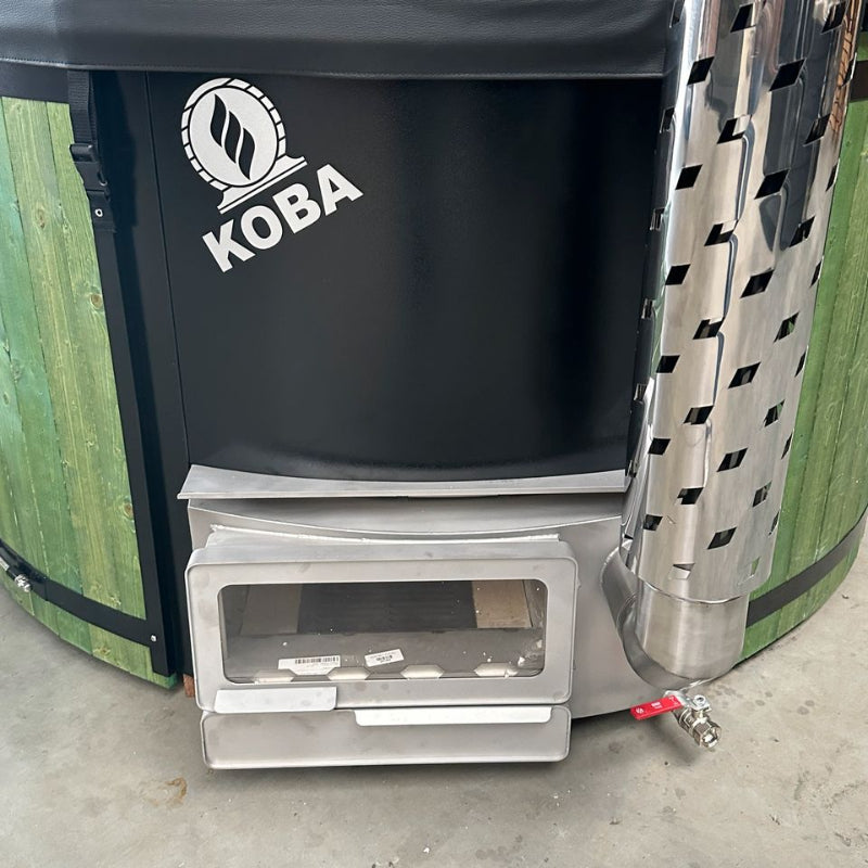 Koba Hot Tub BASIC Whirlpool in Grün mit schwarzem Ofen und Holzverkleidung, Detailansicht des integrierten Ofenbereichs mit Feuerraum.