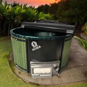 Koba Hot Tub BASIC Whirlpool in Grün mit schwarzem Deckel im Garten bei Sonnenuntergang