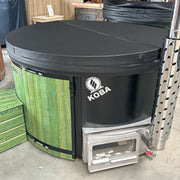 Koba Hot Tub BASIC Whirlpool mit grüner Holzverkleidung und schwarzem Deckel, Feuerbox sichtbar, Ausstellungsansicht