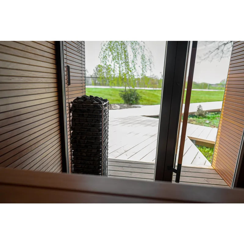 Huum Cliff elektronischer Saunaofen Standofen in moderner Sauna mit Glastüren und Gartenblick
